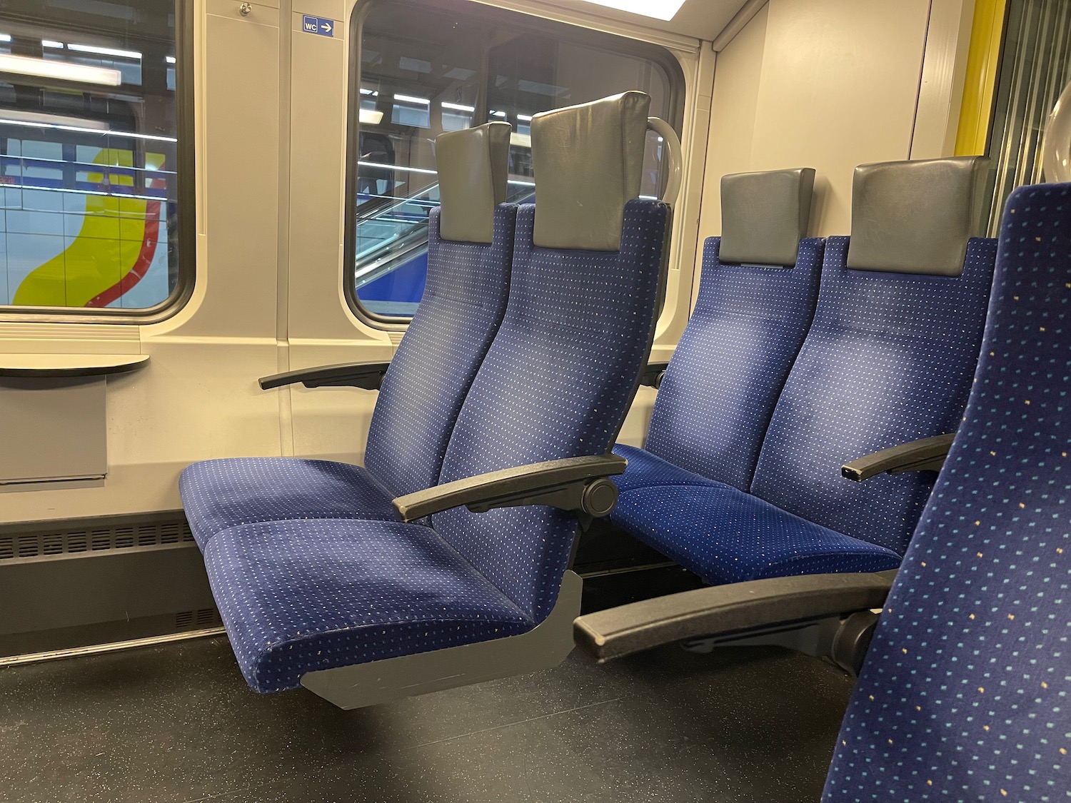 a blue and grey seats in a train