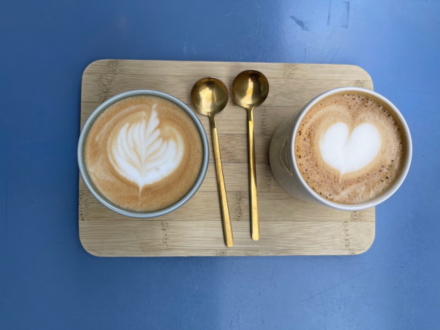 two cups of coffee with a heart shape in the foam