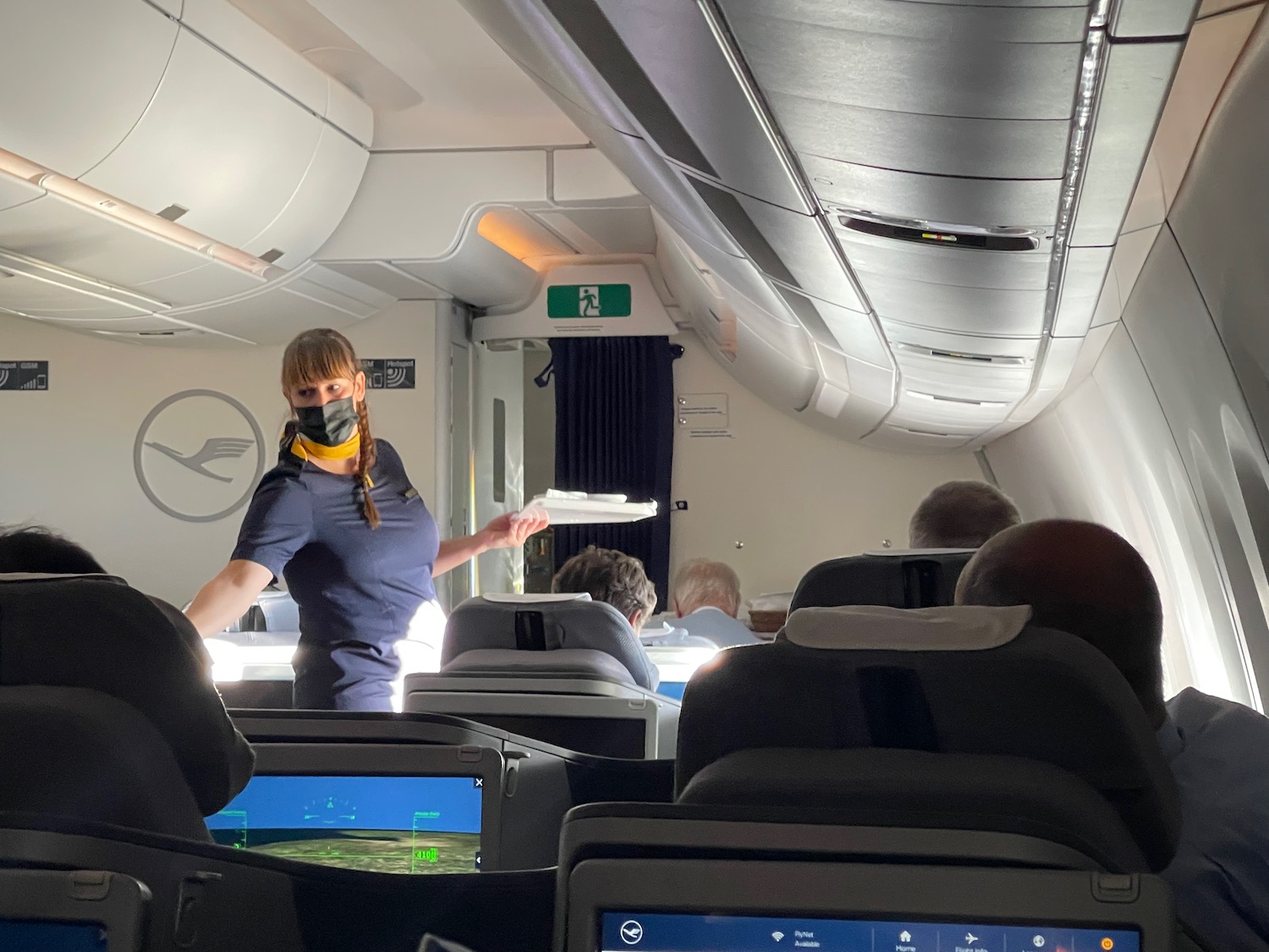 a woman wearing a mask and standing in an airplane