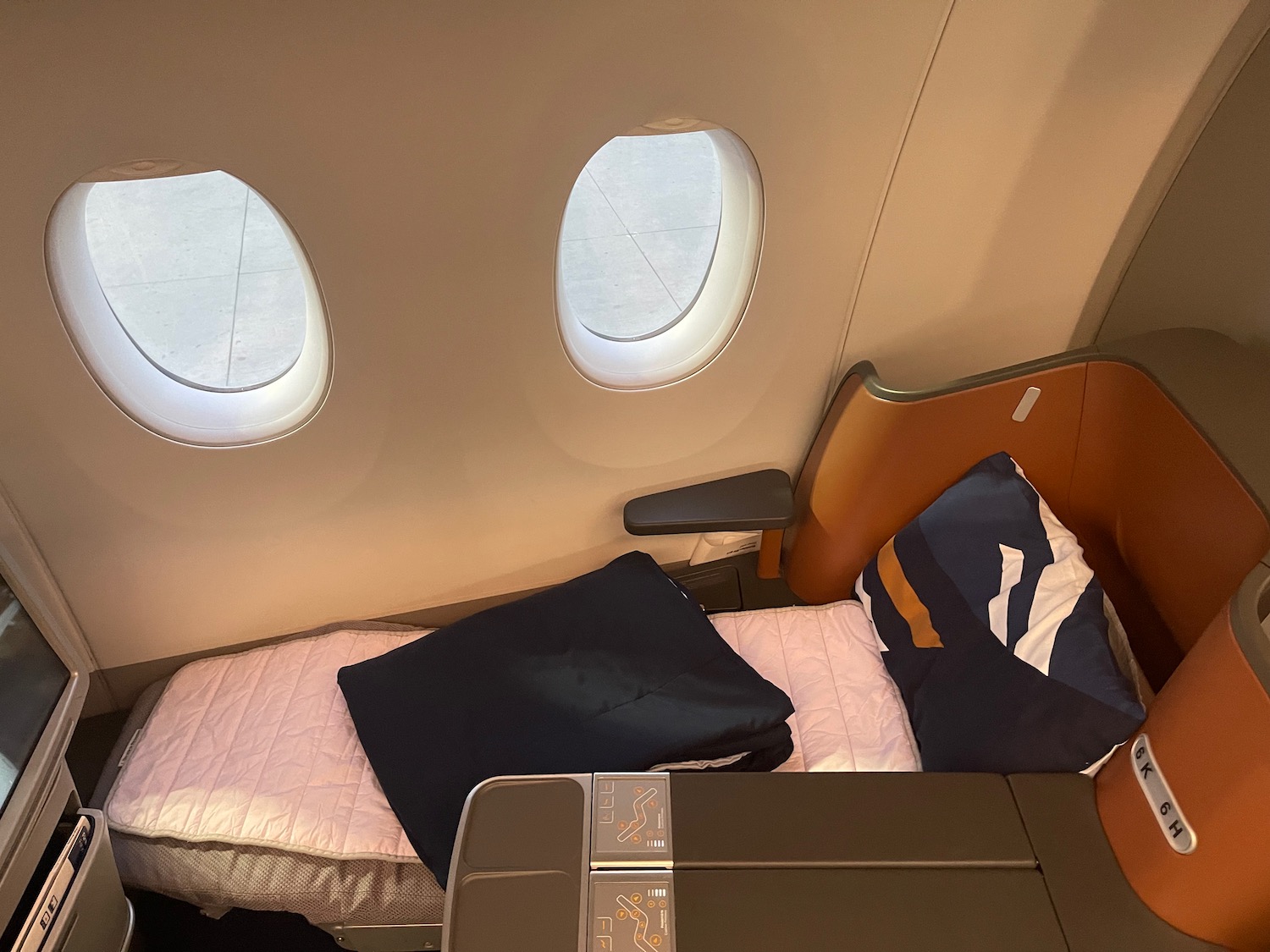 a bed with pillows and a table in a plane