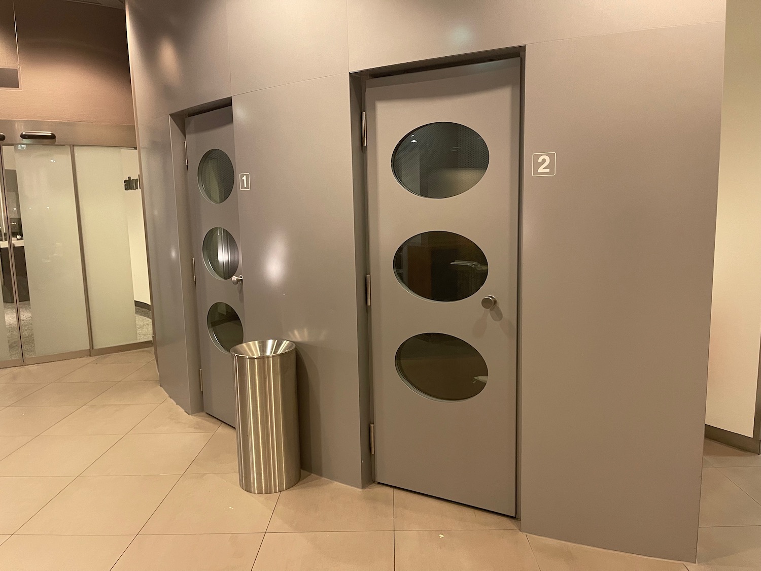 a door with oval windows and a trash can