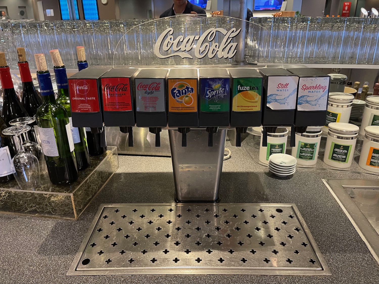 a soda dispenser with bottles and bottles on a counter