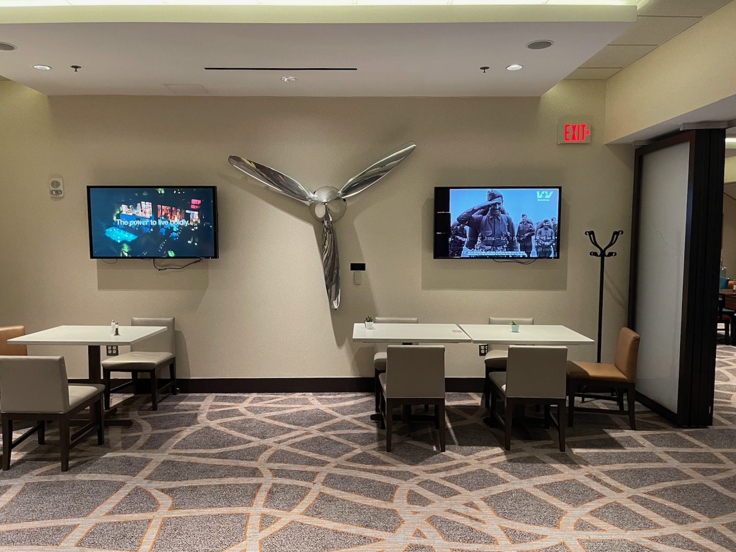 a room with tables and tvs on the wall