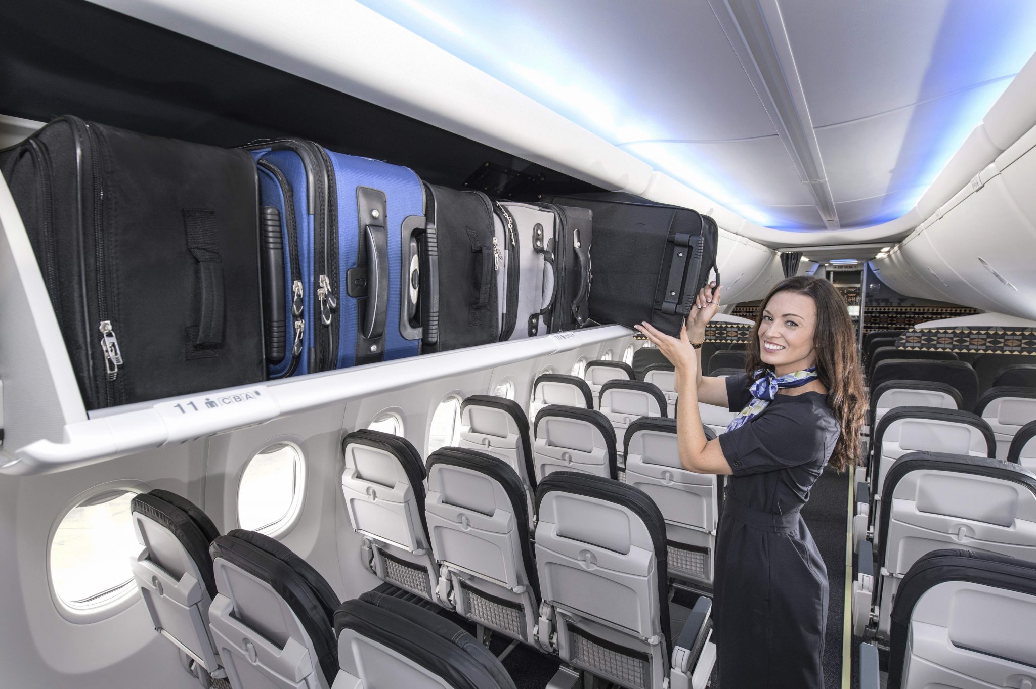 a woman in a flight attendant holding a luggage rack