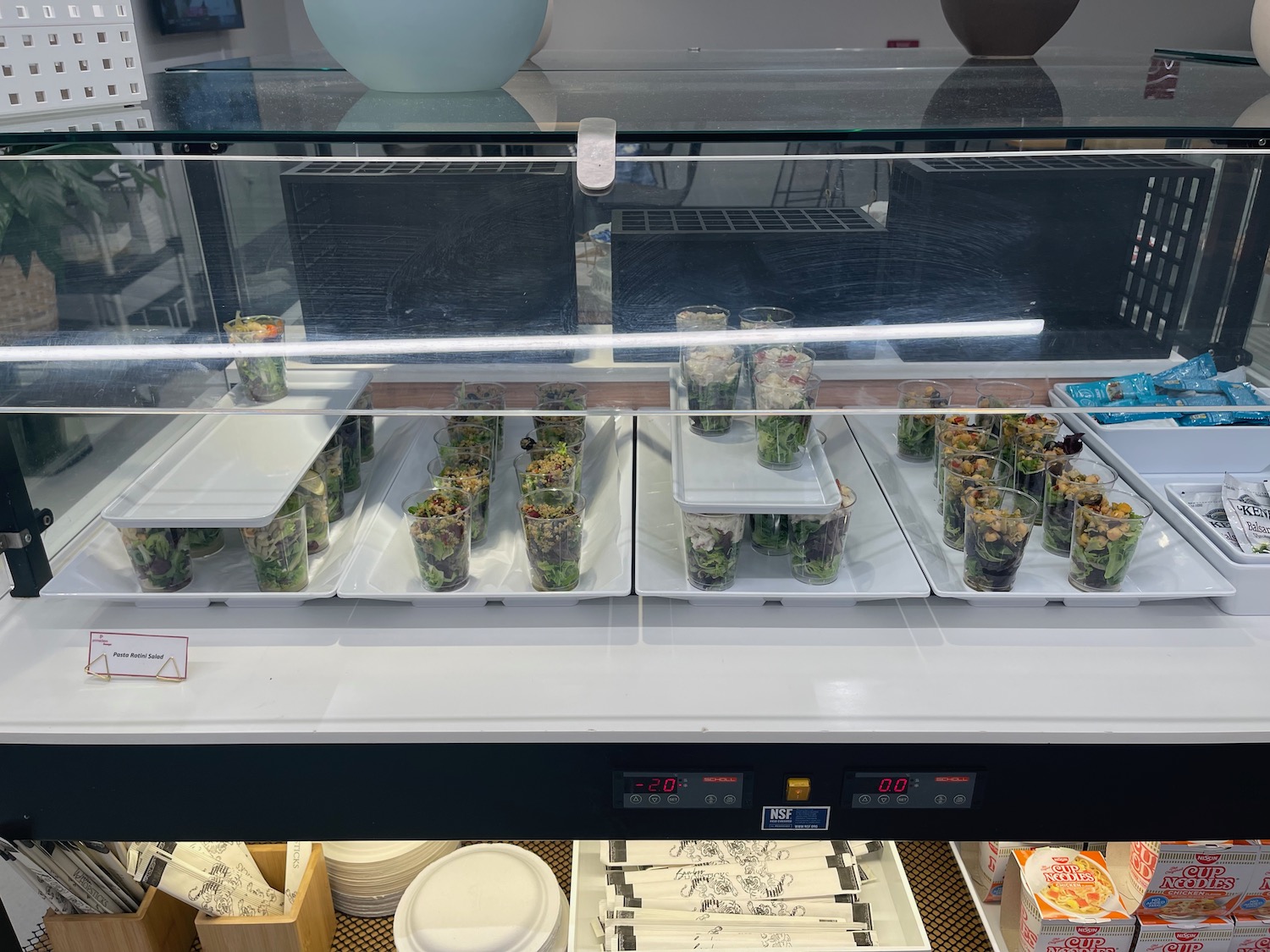 a display case with plastic cups of food