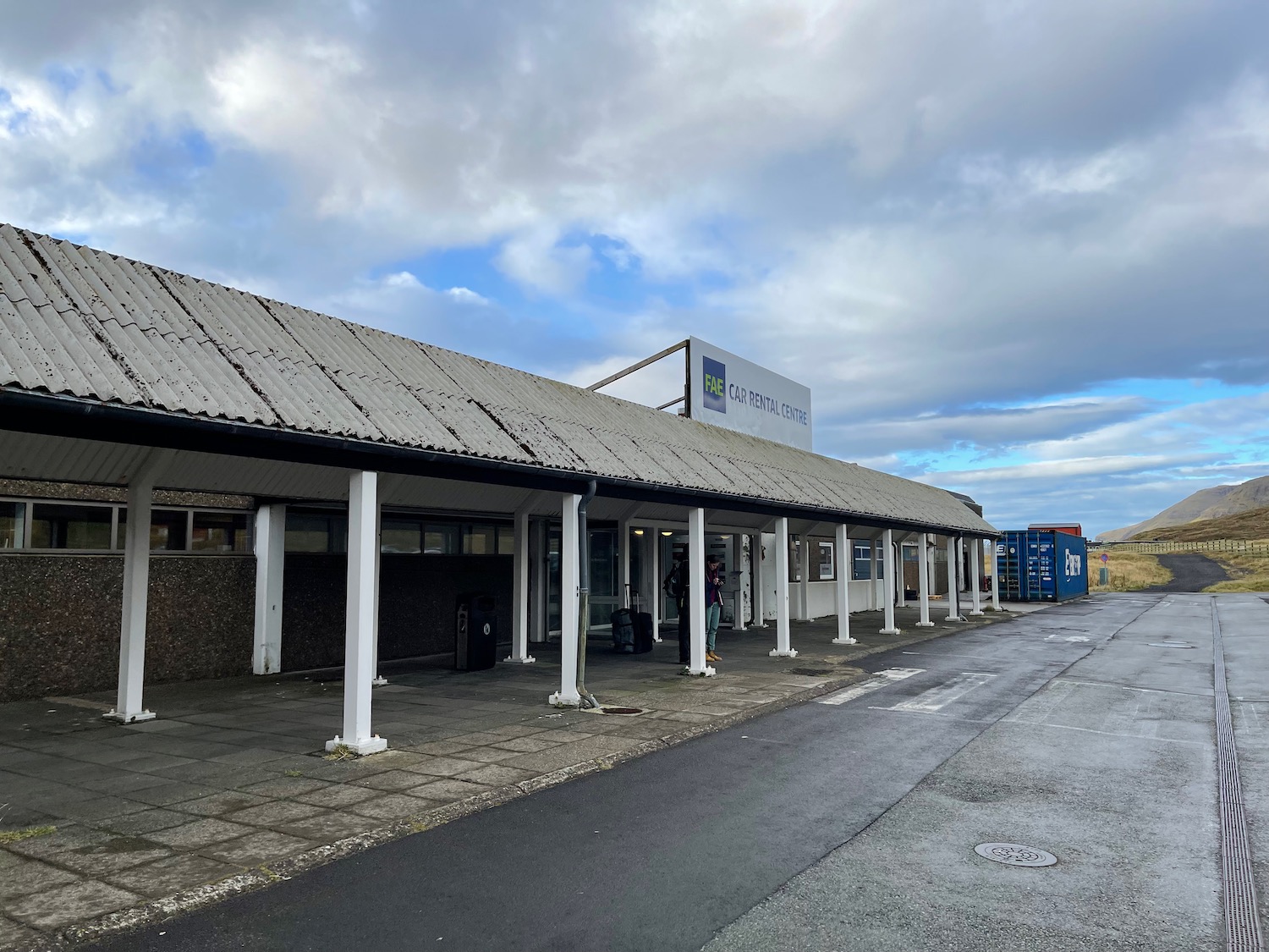 a building with white pillars and a sign on the side of the road