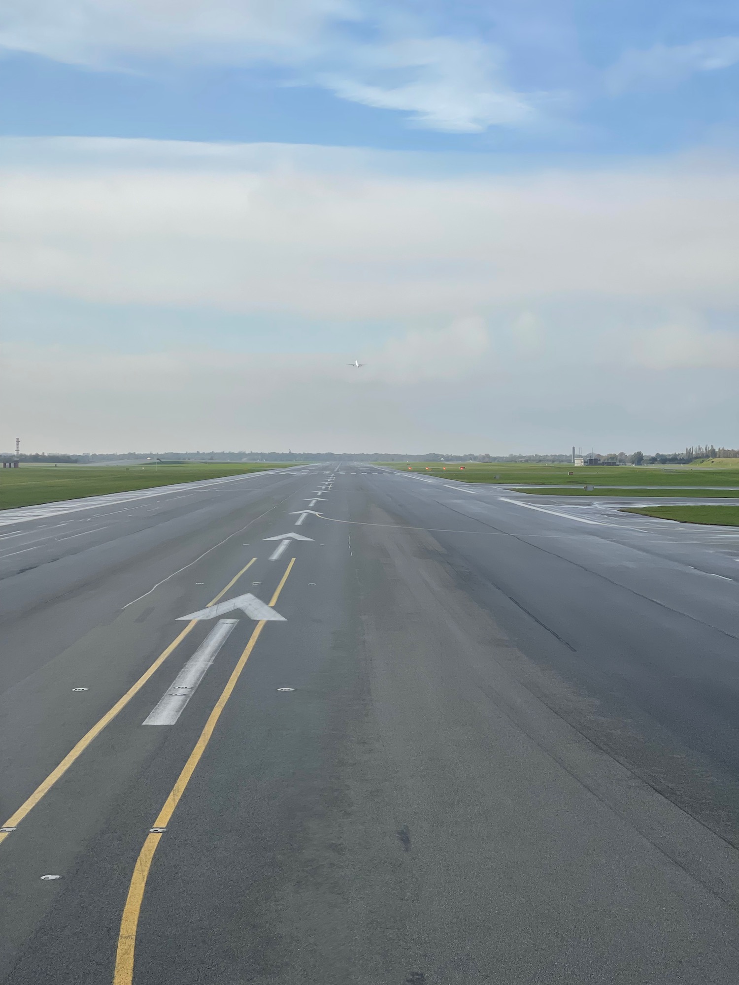 an empty road with an arrow pointing to the horizon