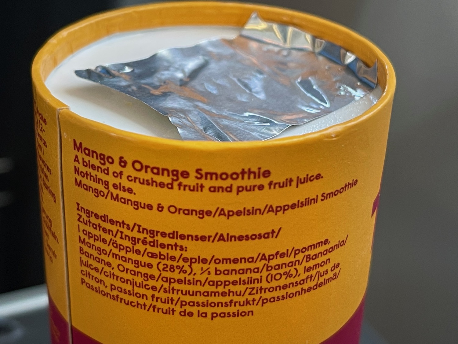 a yellow container with a white and orange smoothie in it