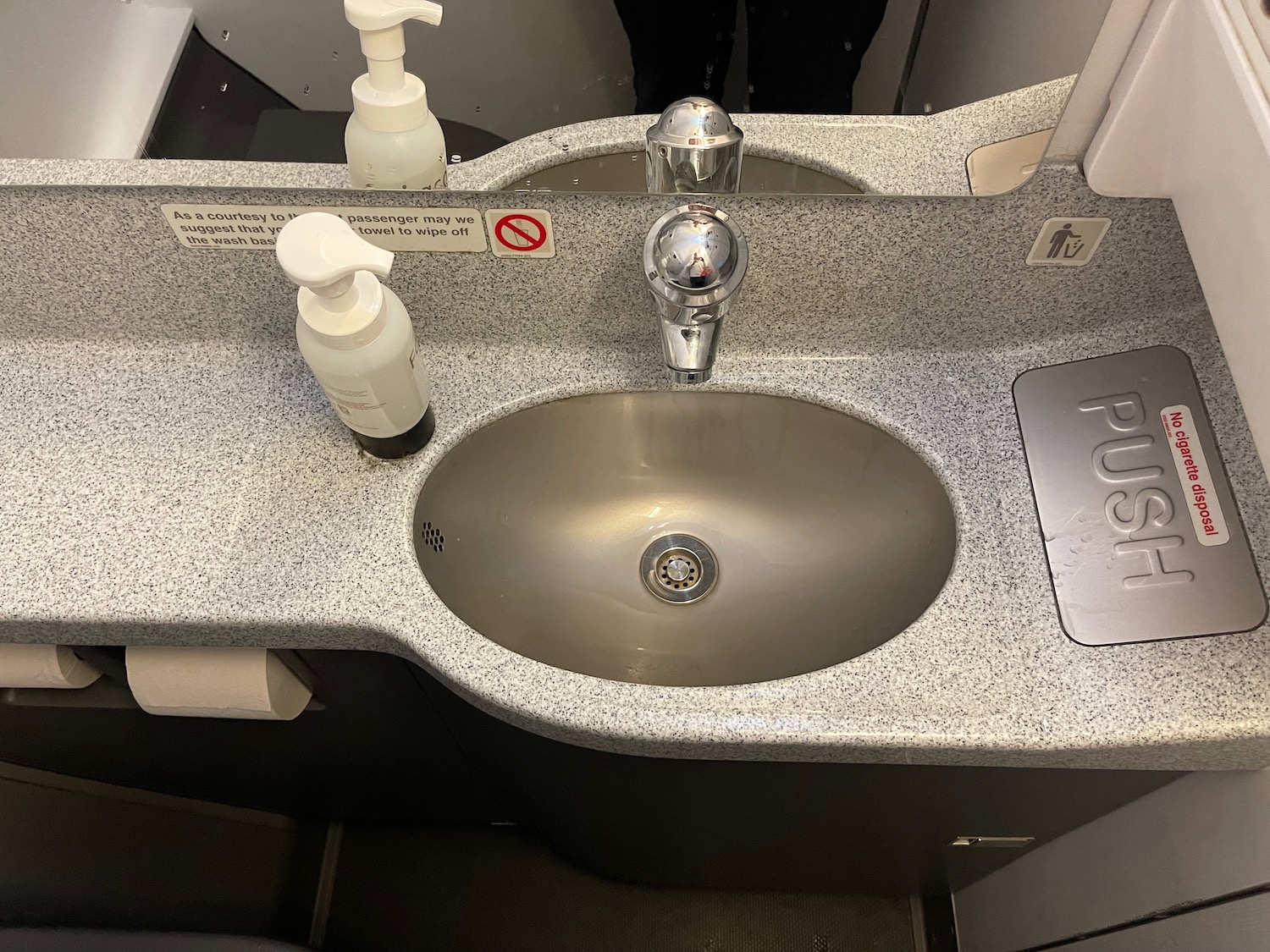 a sink with soap dispensers and a mirror