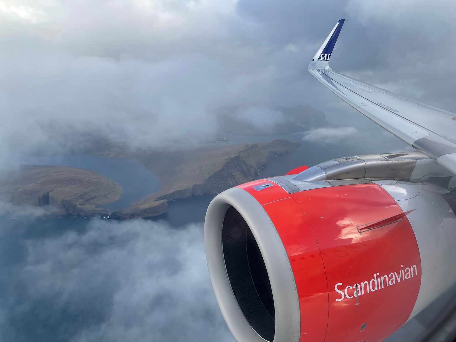 an airplane wing and engine above clouds