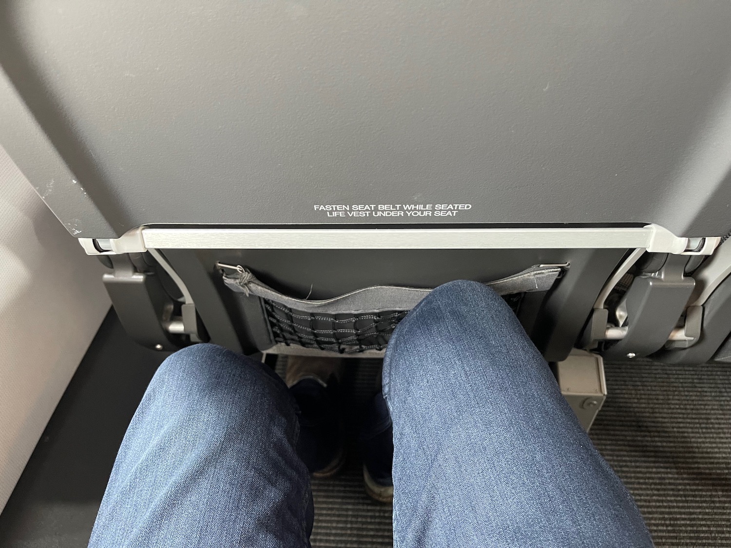 a person's legs in jeans and a seat belt