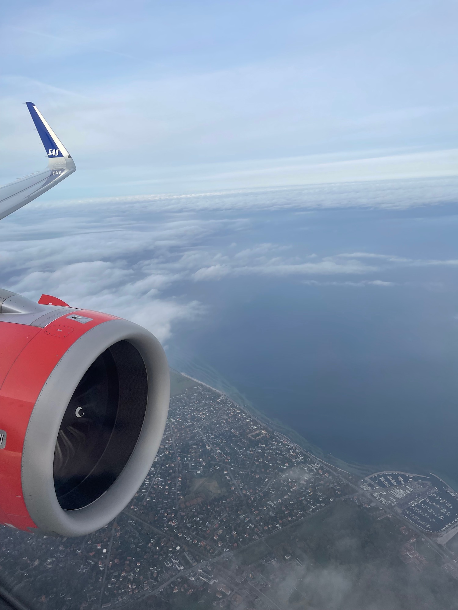 an airplane wing and engine above clouds