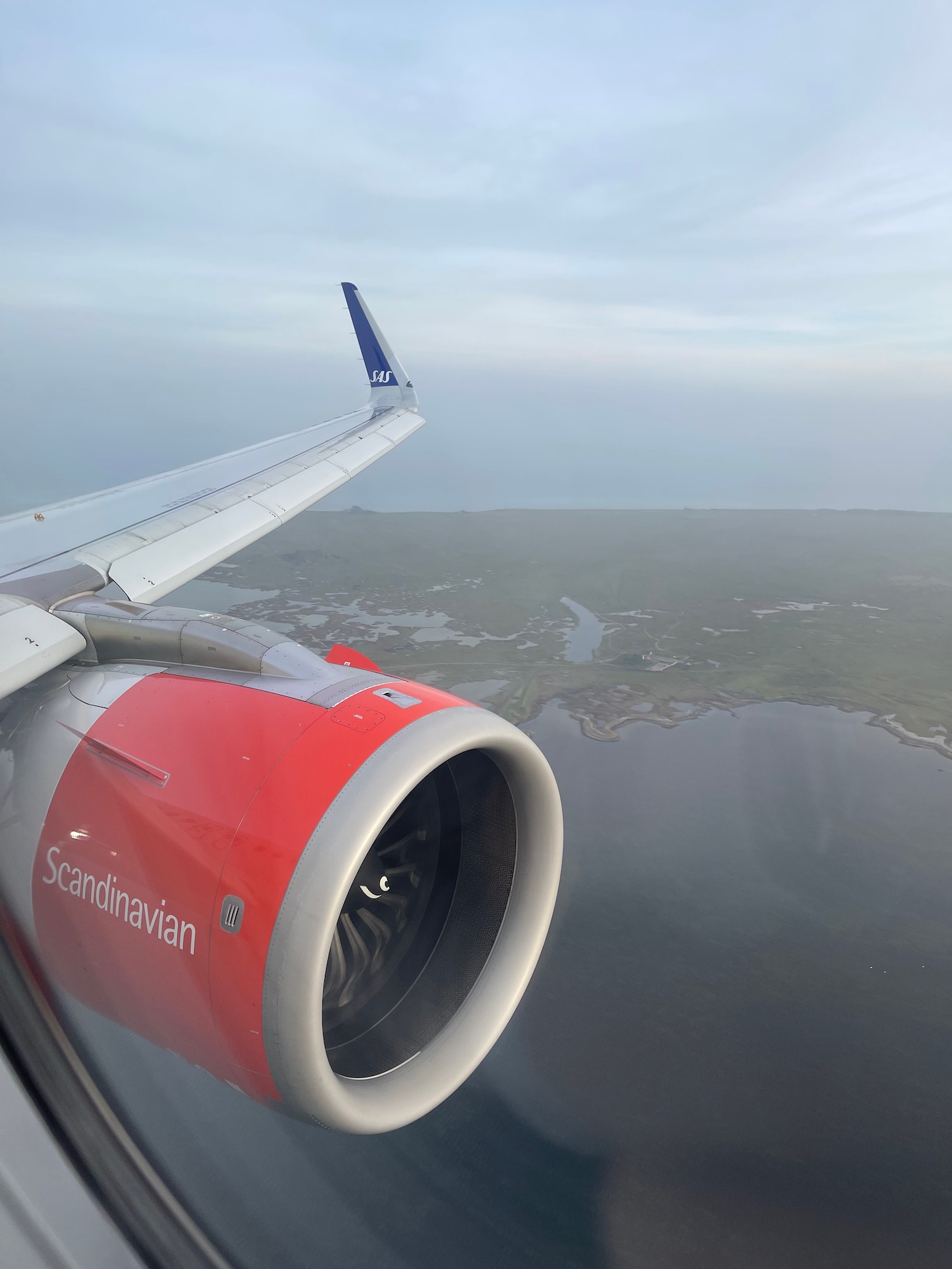 an airplane wing and engine above land