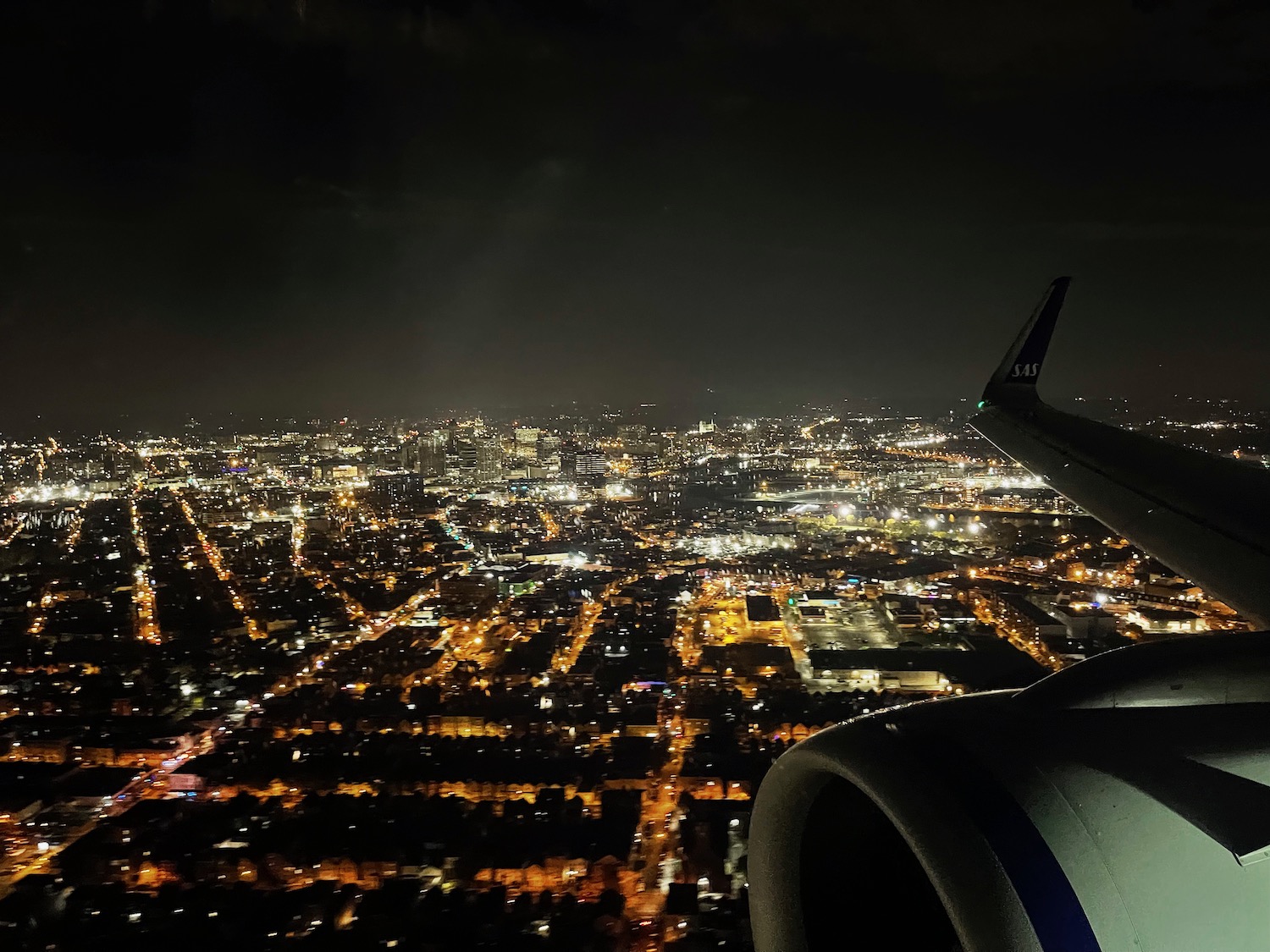 an airplane wing and a city at night