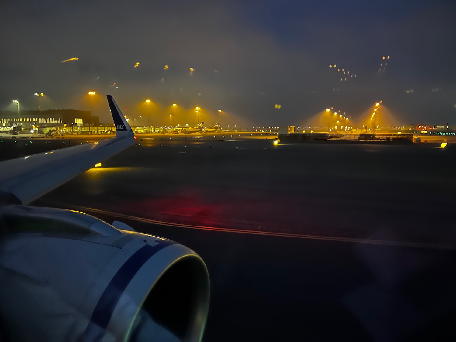 an airplane wing and a runway at night