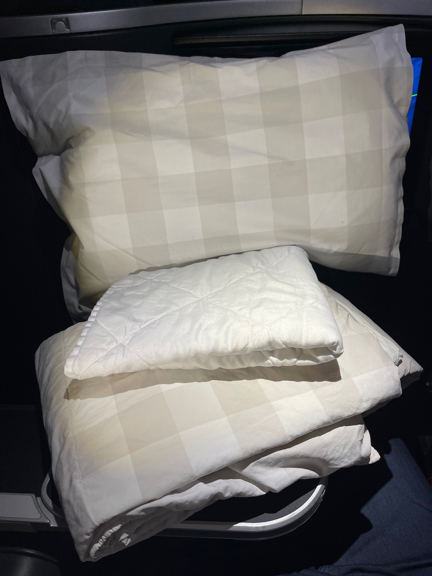 a stack of white pillows and blankets