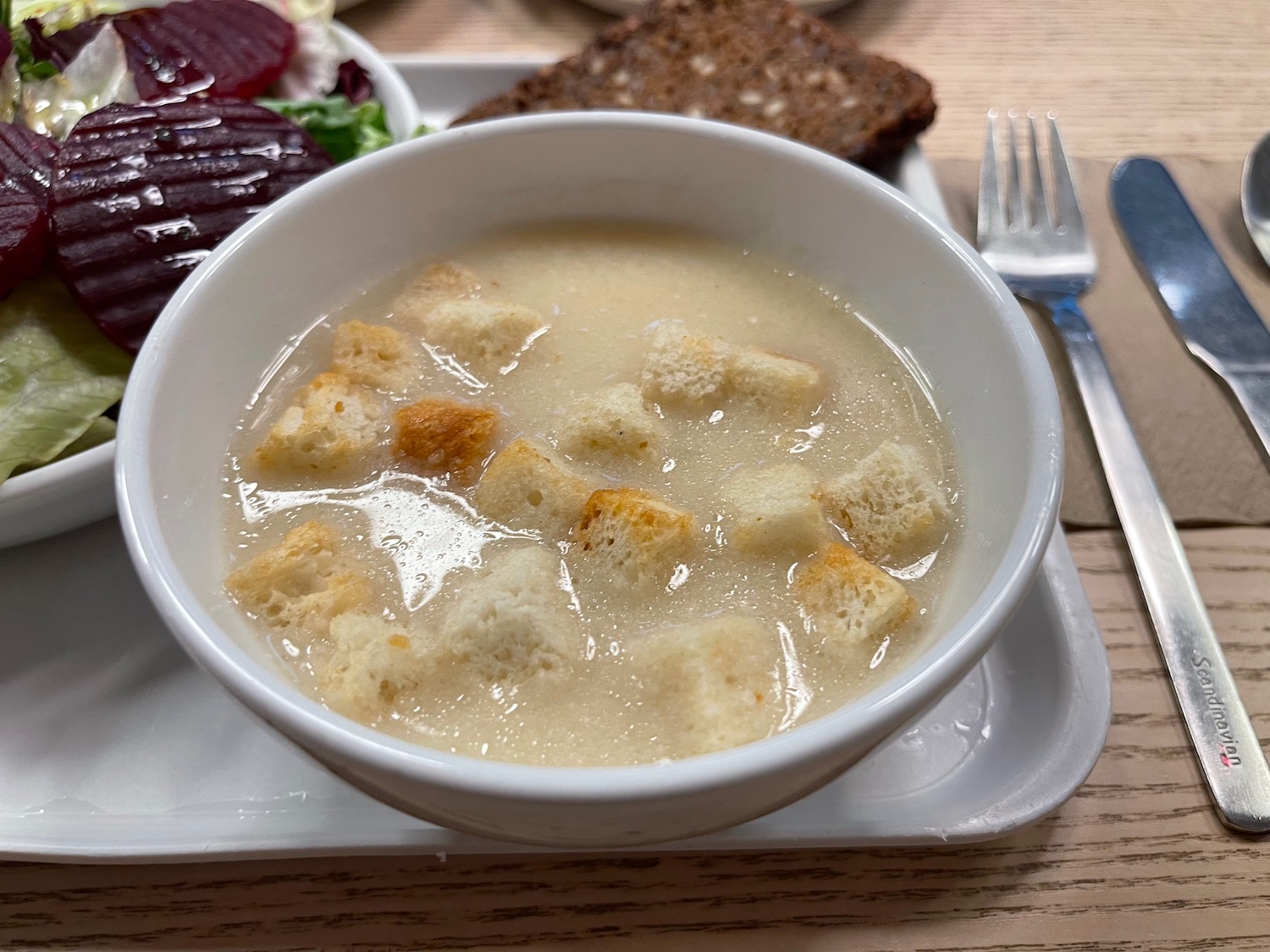 a bowl of soup with croutons on a plate