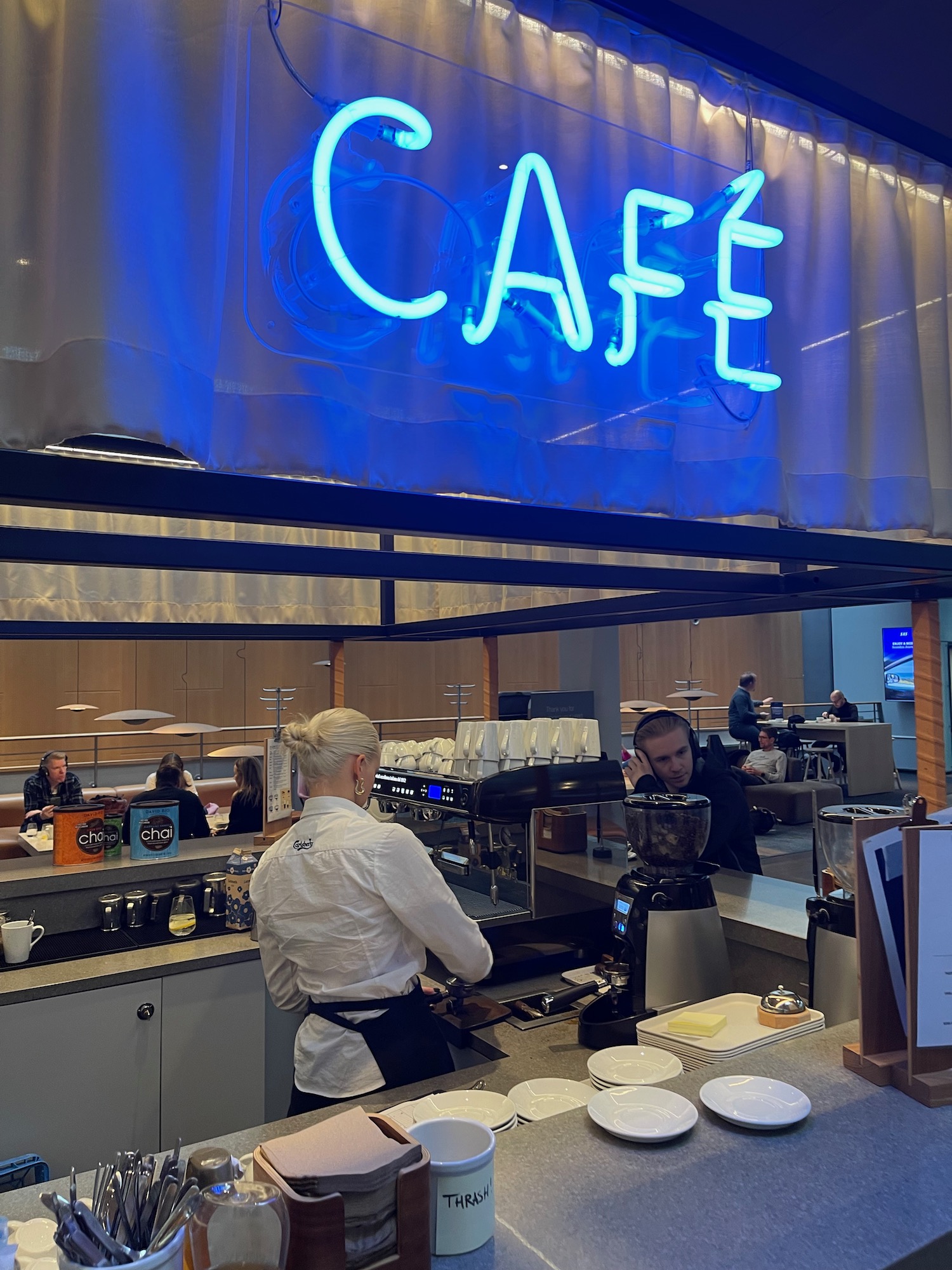 a woman standing behind a counter in a cafe