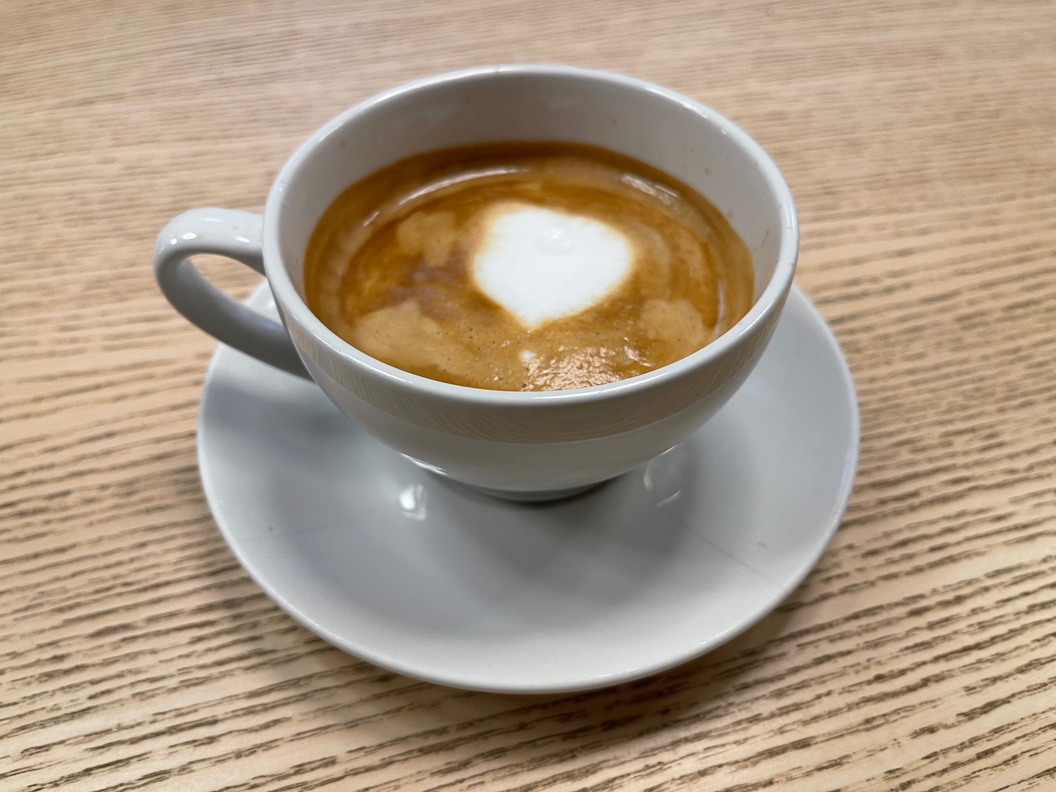 a cup of coffee with a heart in the foam