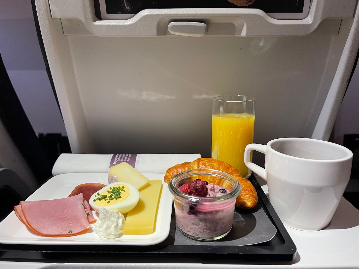 food on a tray with a cup of juice and a glass of orange juice