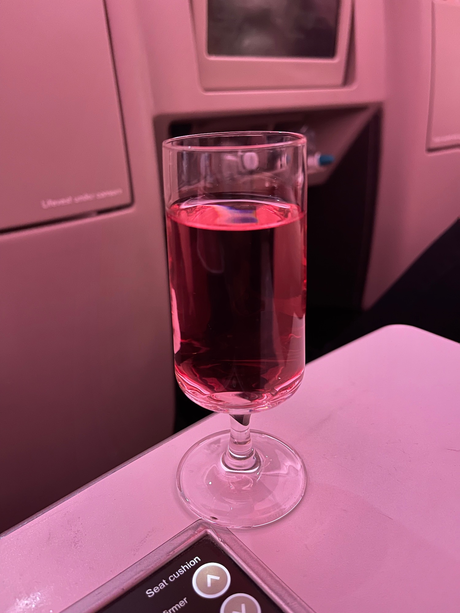 a glass of pink liquid on a table