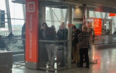 people standing in a glass booth