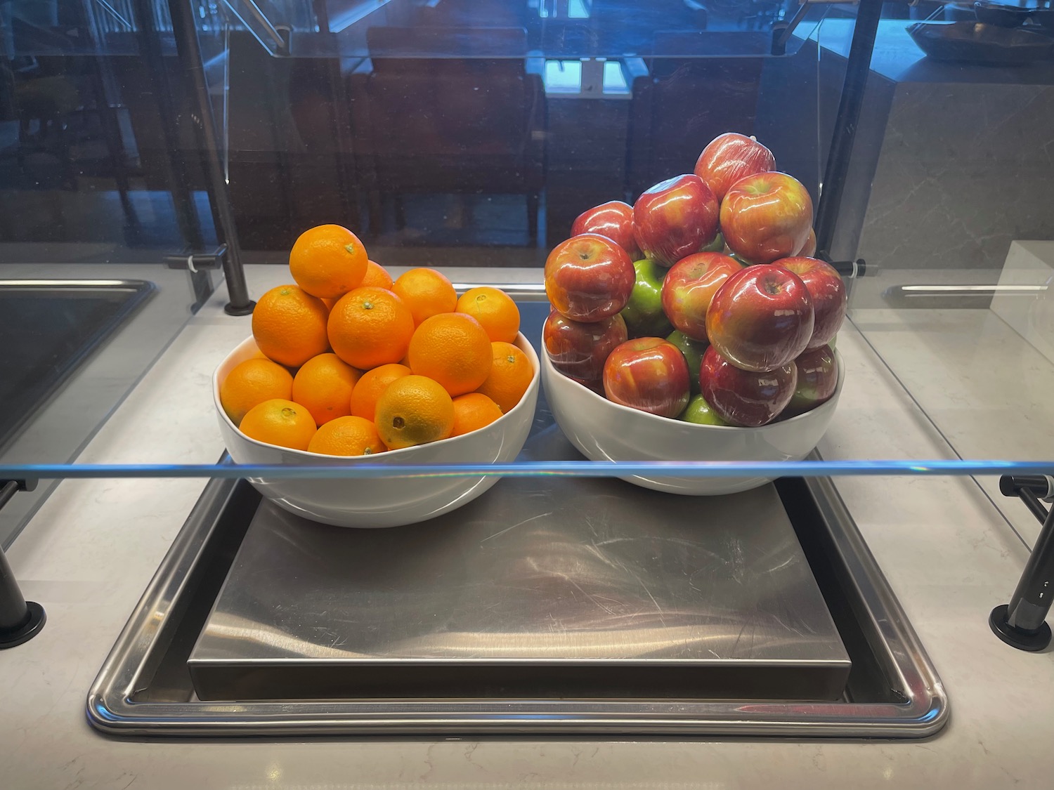 a bowl of apples and oranges on a counter