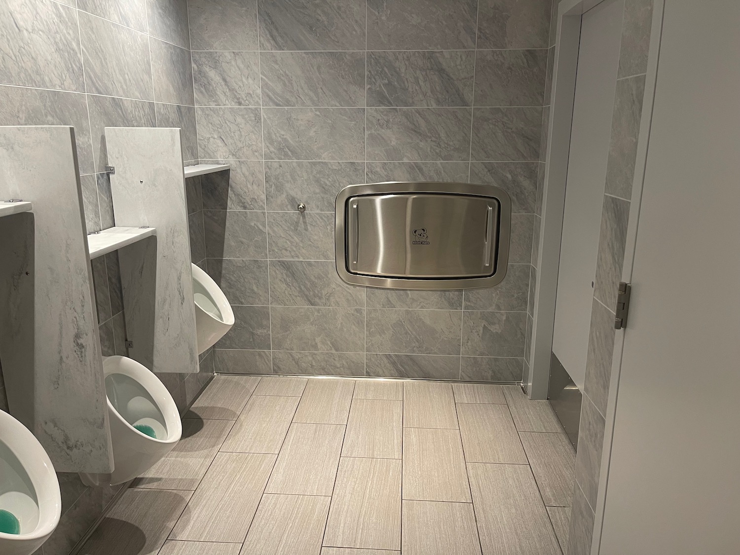 a bathroom with a urinal and a tile floor