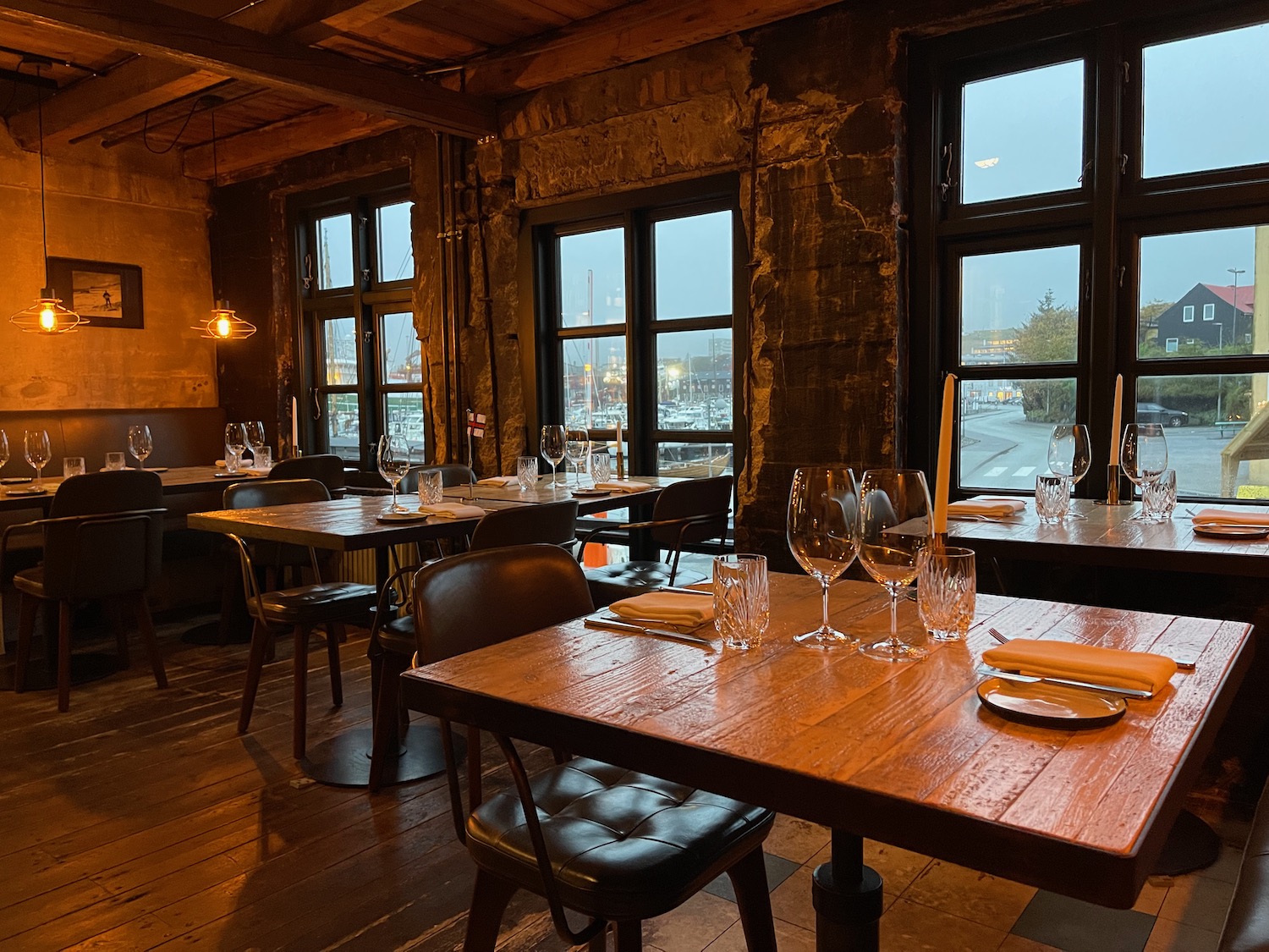 a room with tables and chairs and wine glasses