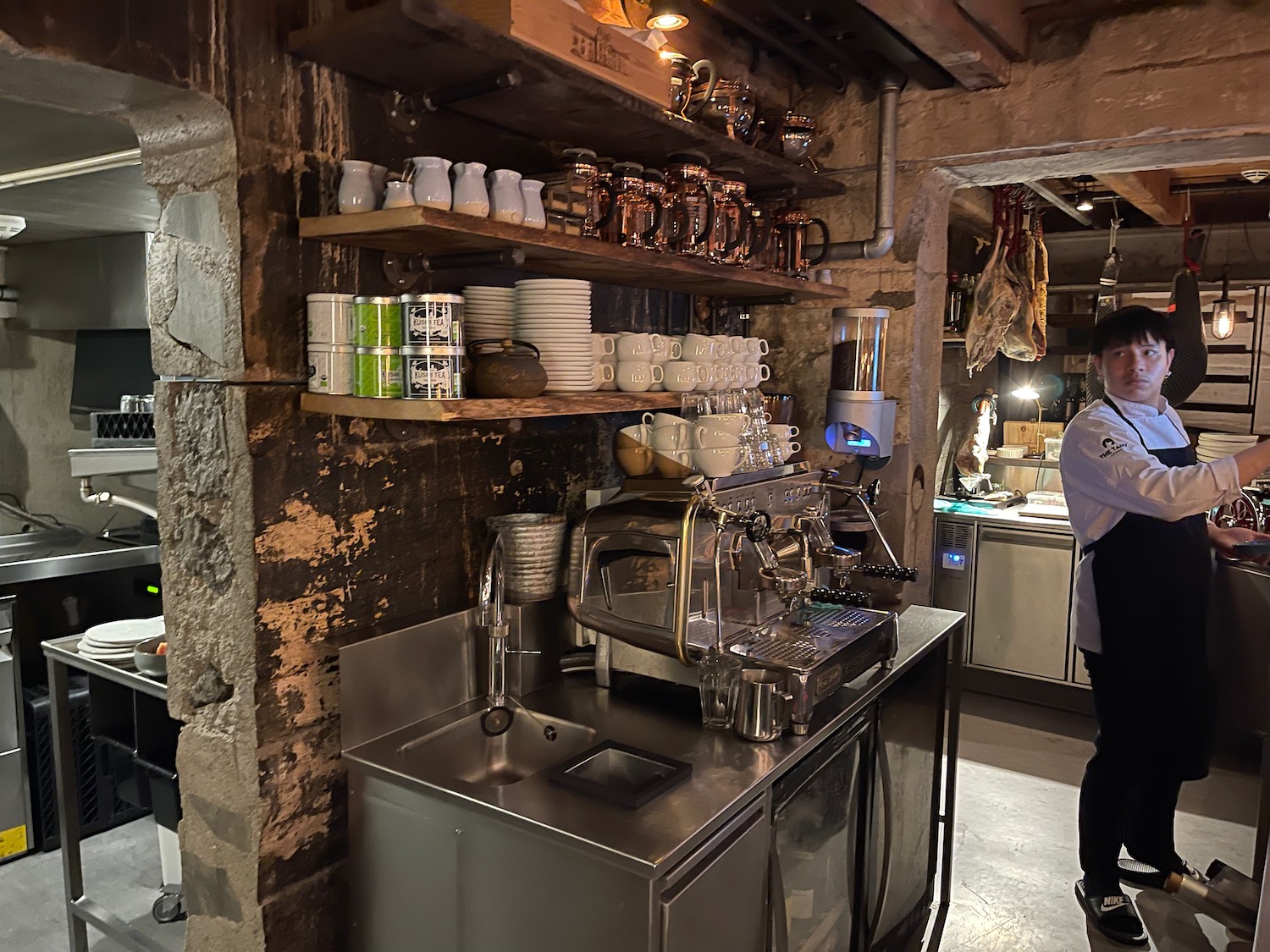 a man standing next to a counter with a coffee machine