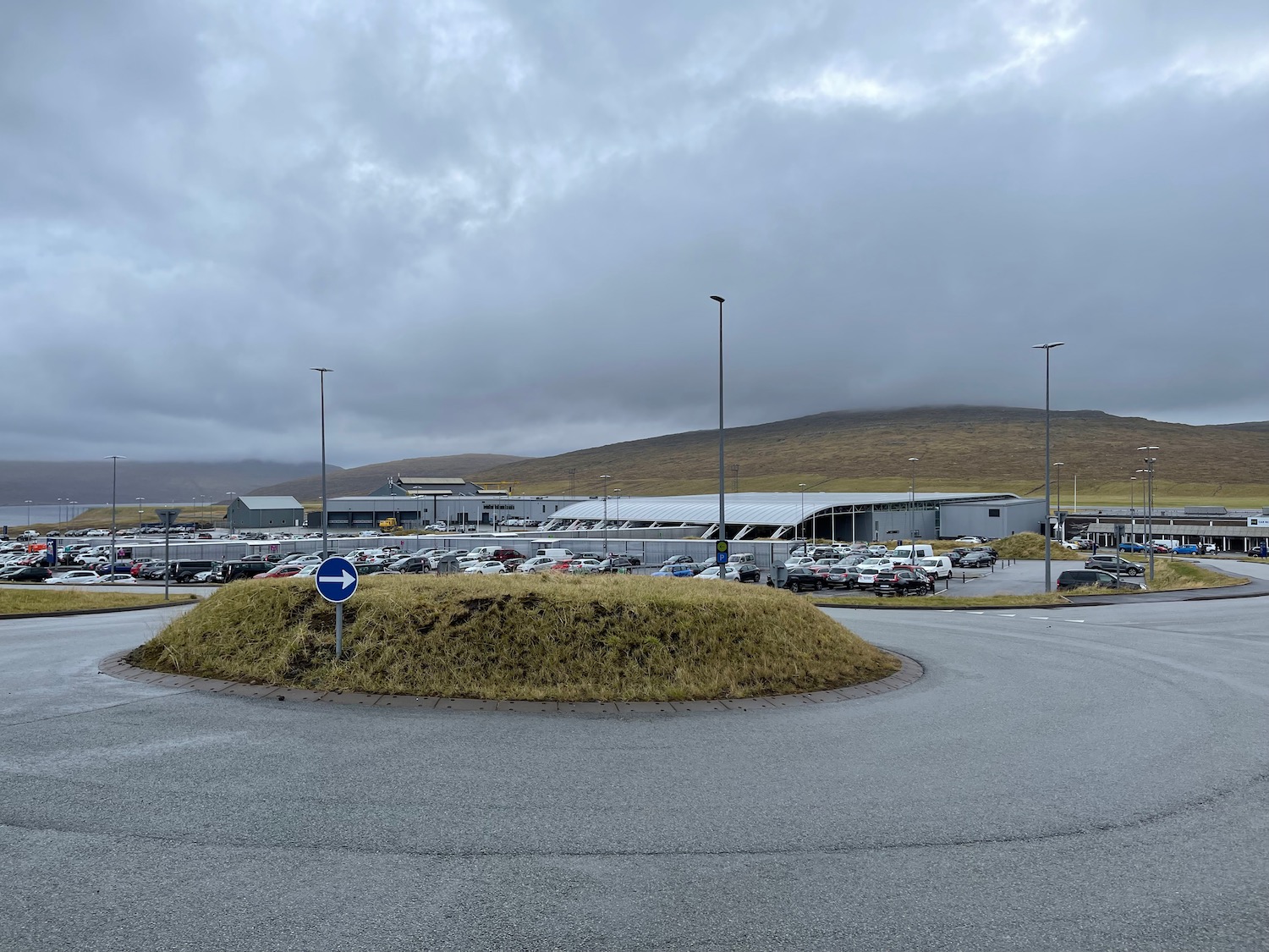 a parking lot with a hill and a building