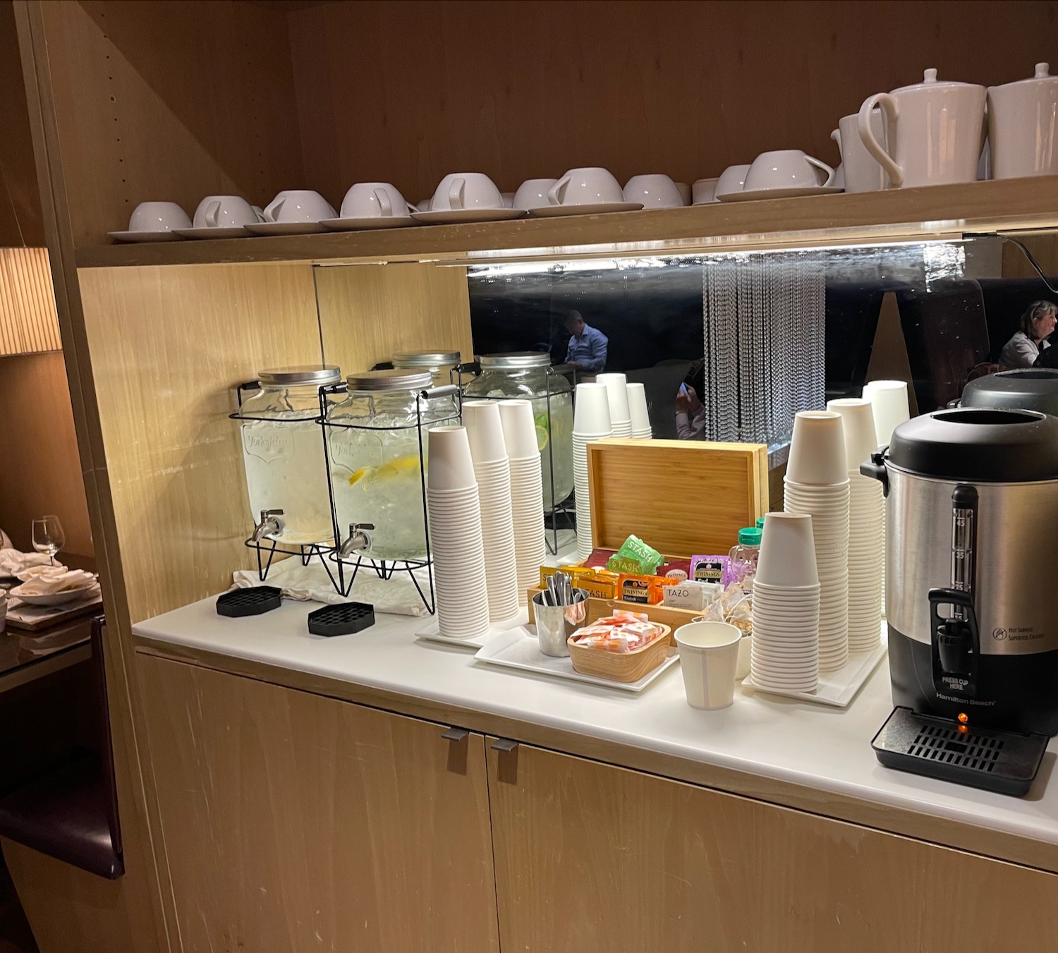 a counter with a variety of cups and coffee maker