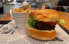 a burger and potato chips on a newspaper