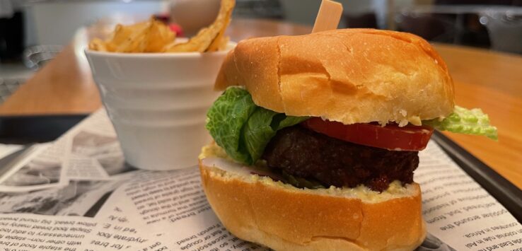 a burger and potato chips on a newspaper