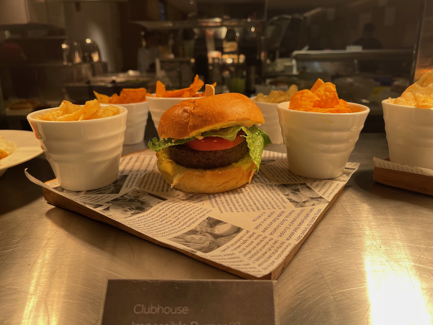 a burger and chips on a paper with a sign