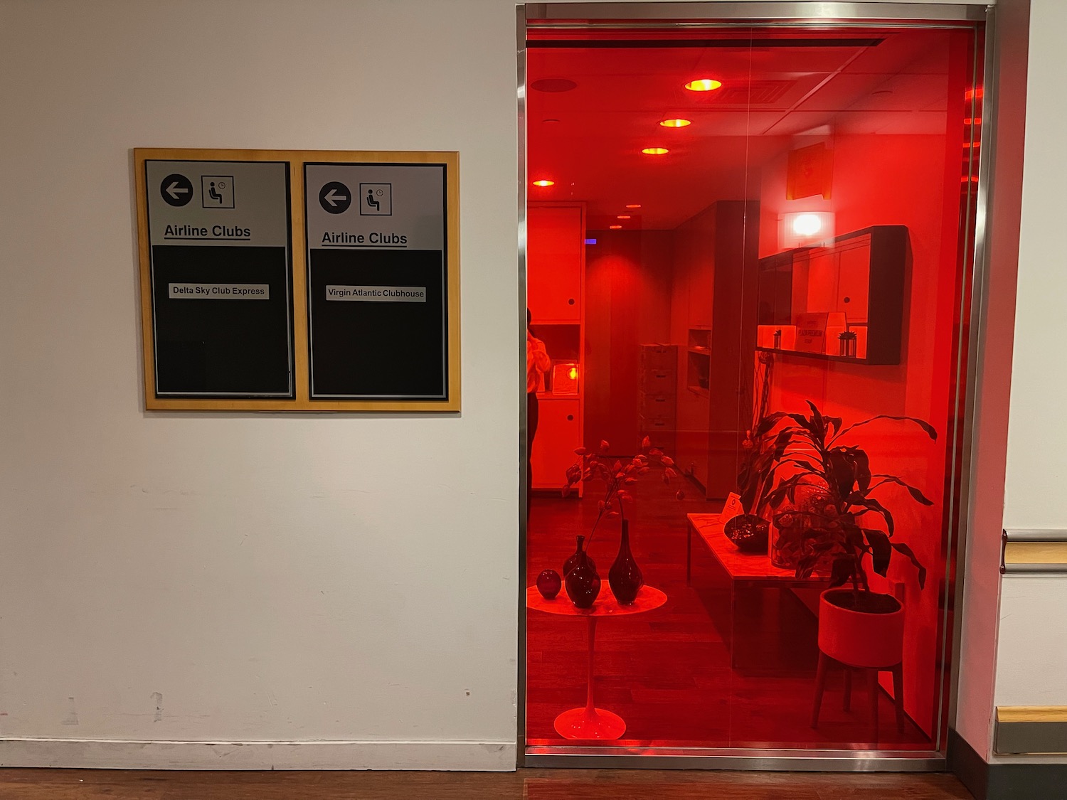 a glass door with a red light reflecting a room