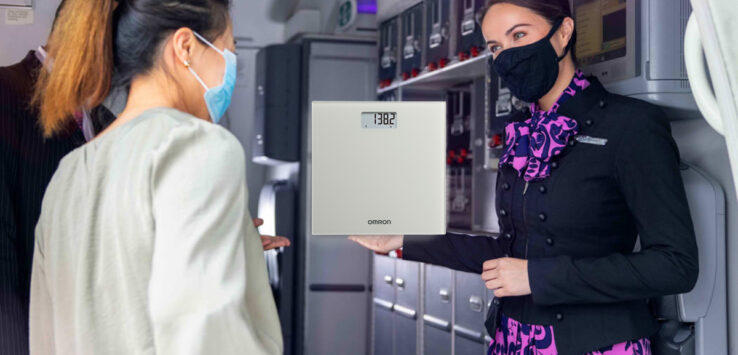 a woman wearing a face mask holding a scale