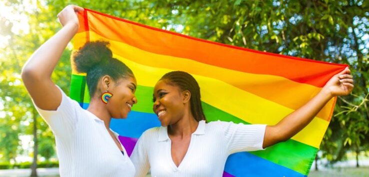 two women holding a rainbow flag