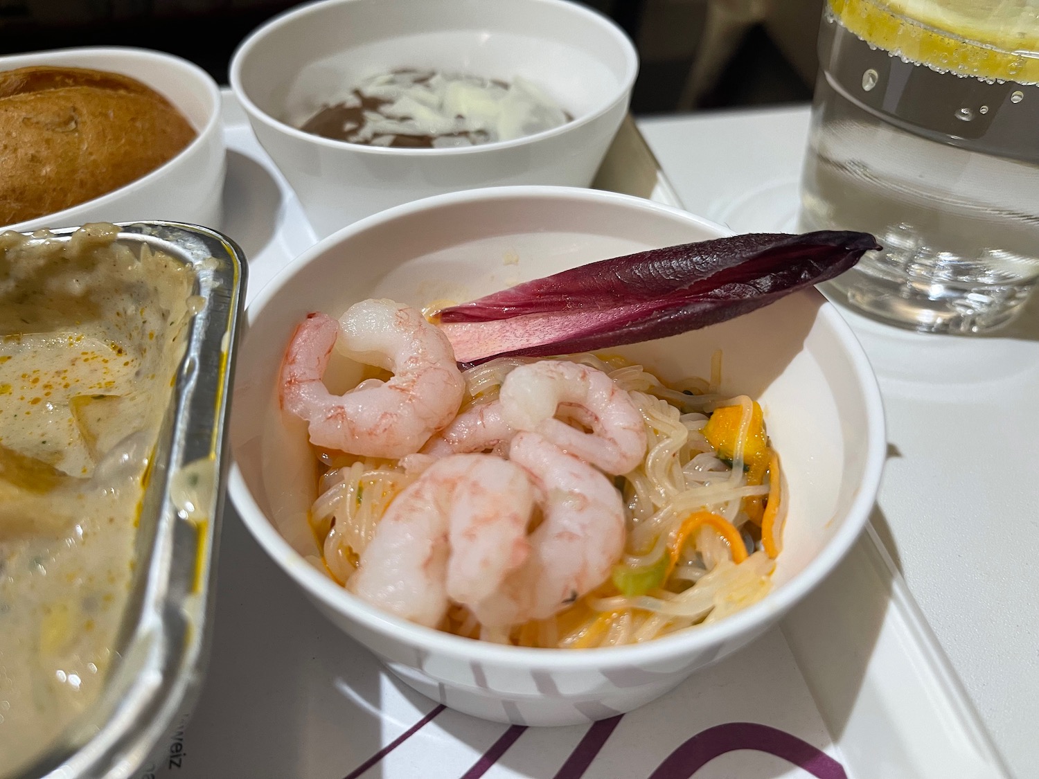 a bowl of noodles with shrimp and vegetables