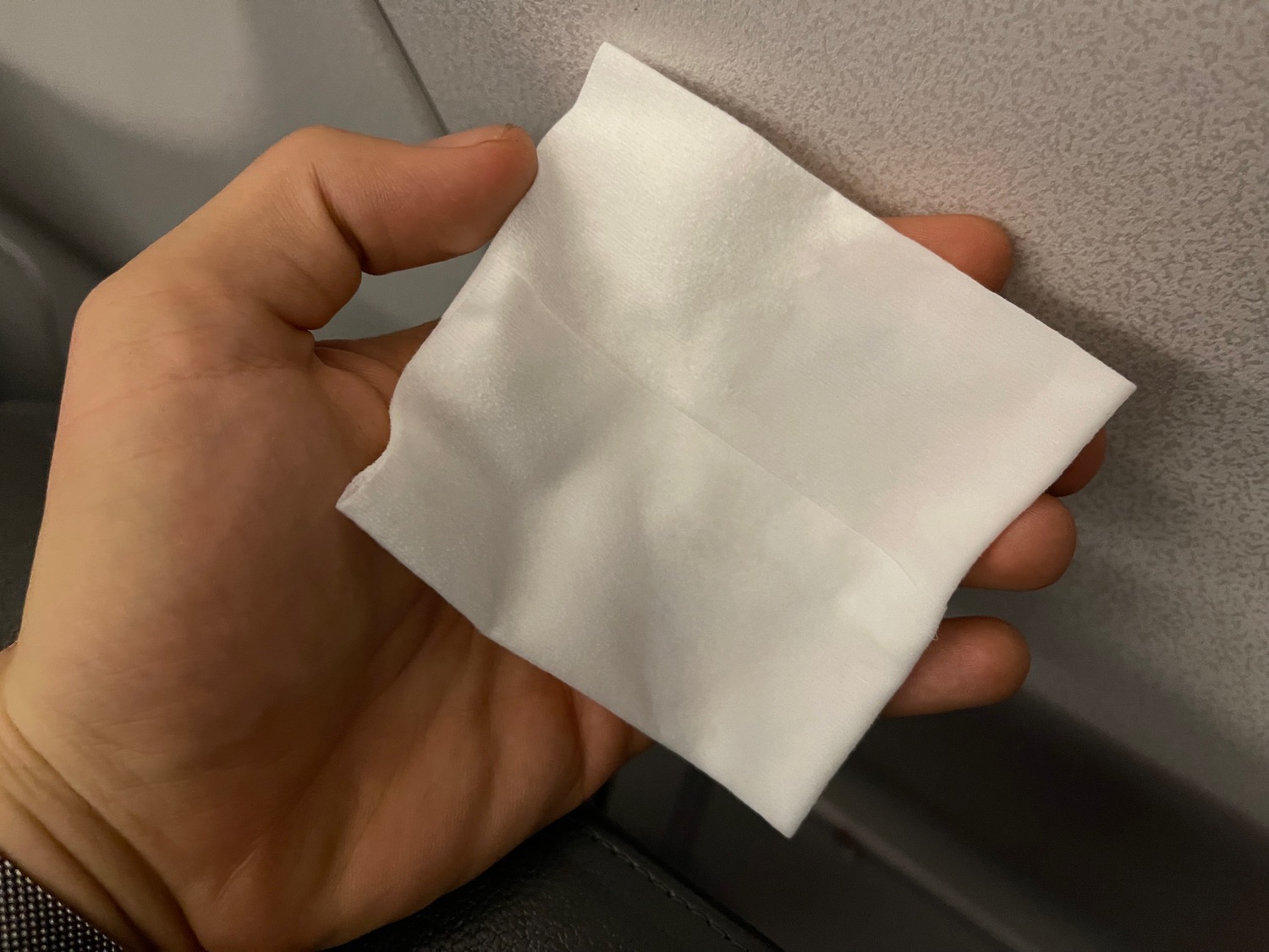 a hand holding a white napkin