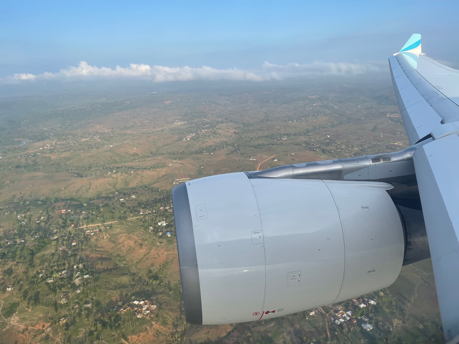 an airplane wing and engine above a landscape