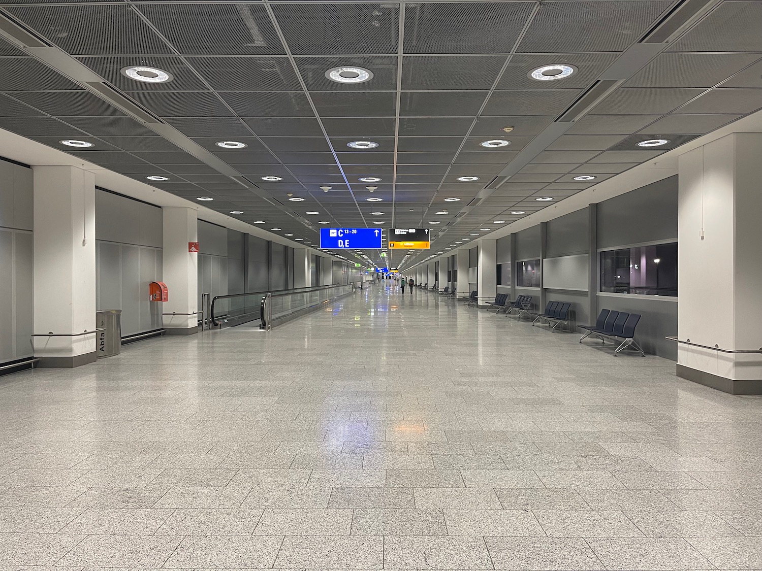 a large airport terminal with chairs and a sign