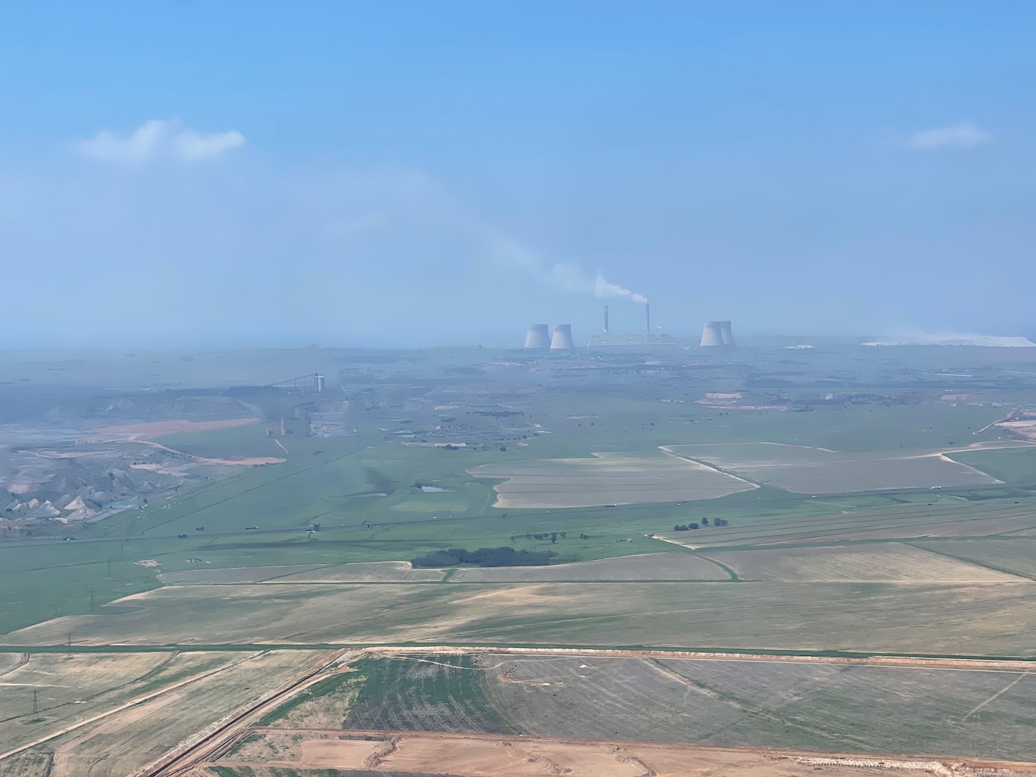 a large field with smoke stacks and smokestacks