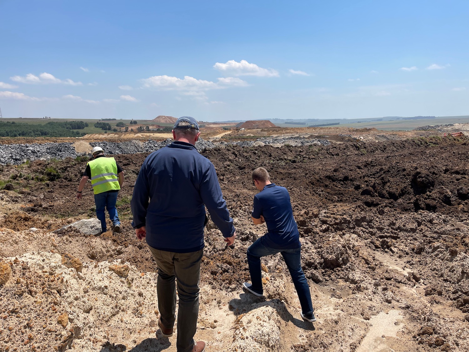 a group of men walking in a dirt field