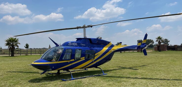 a blue and yellow helicopter on grass