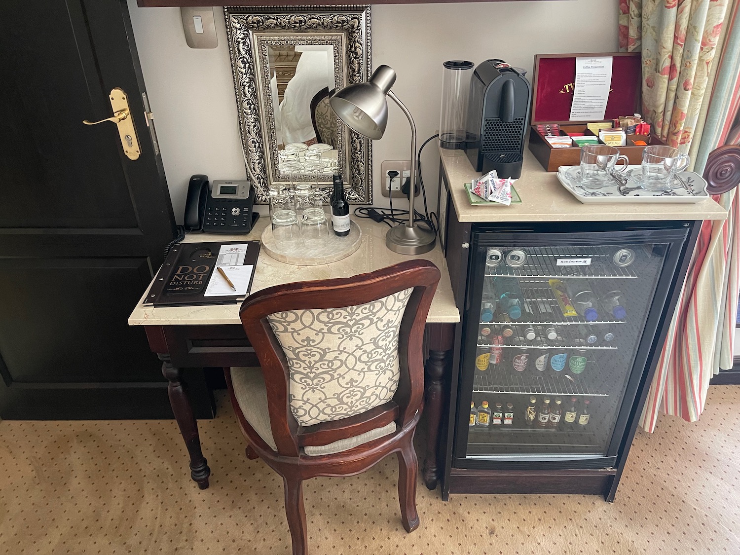 a desk with a chair and a refrigerator