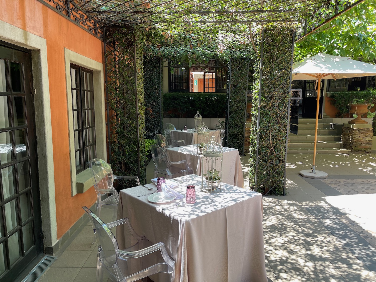 tables and chairs under a pergola