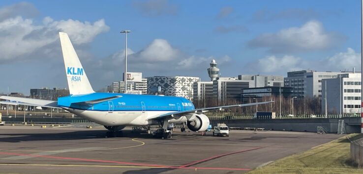 a blue and white airplane on a runway