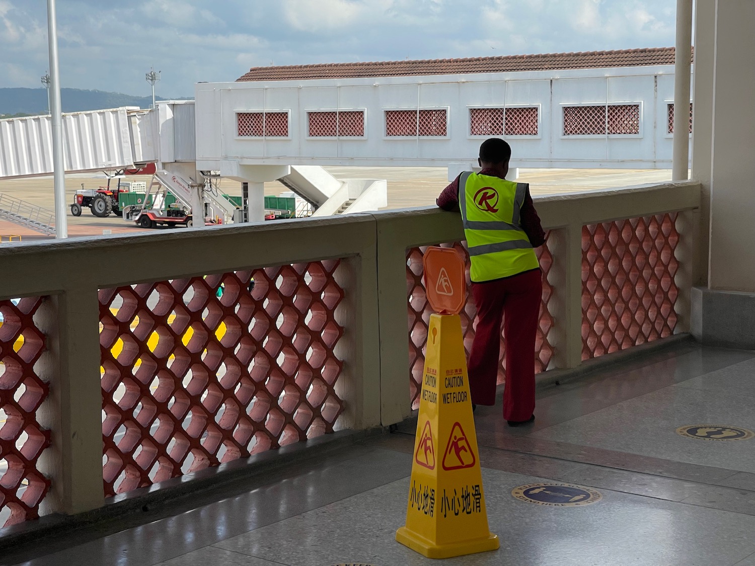 a man in a safety vest standing on a bridge