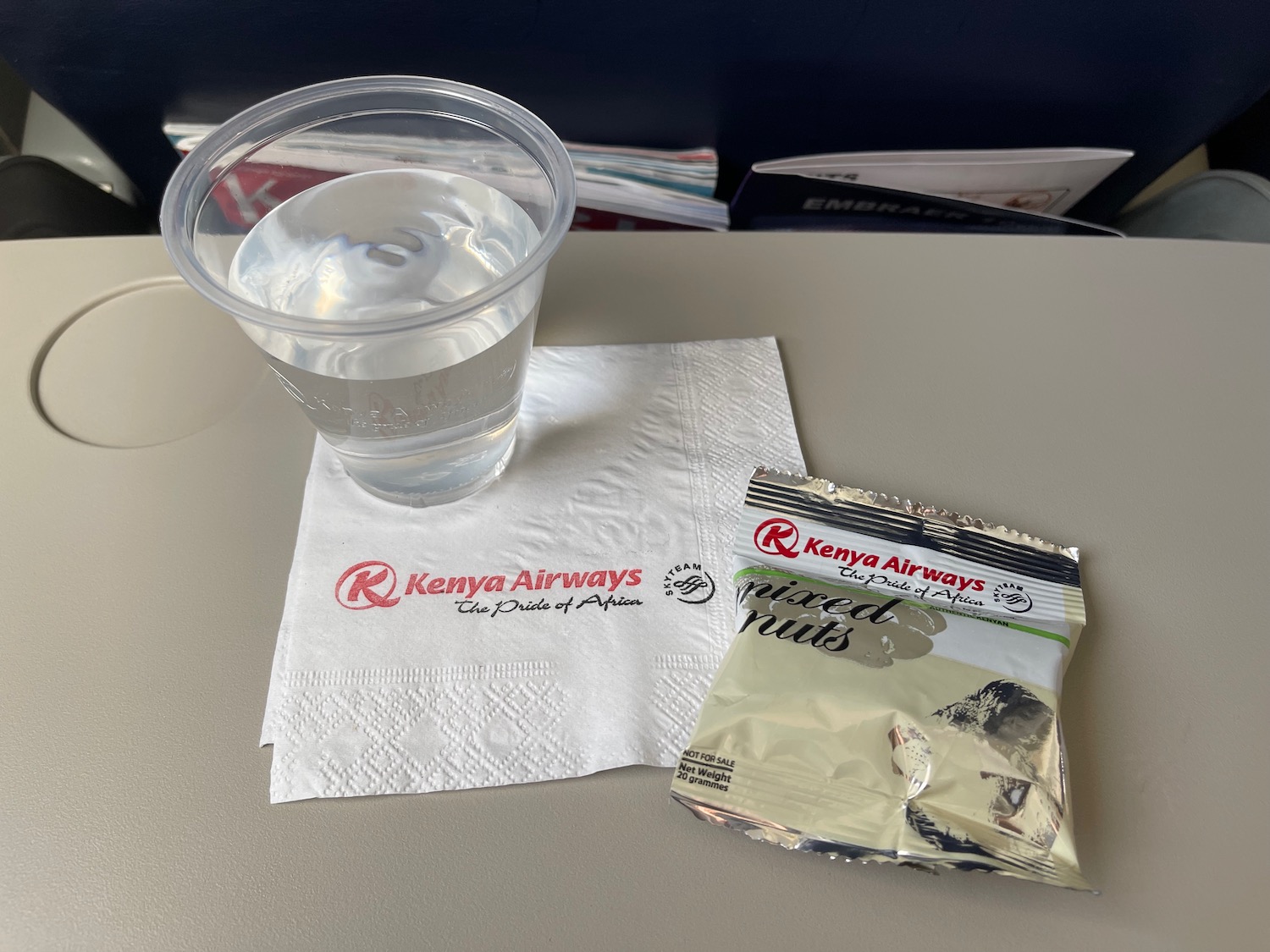 a clear glass of water and a packet of nuts on a napkin